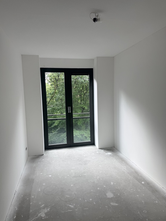 Lichte kamer met glad gestucte wanden en plafond